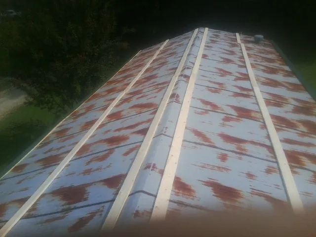 Rusted metal roof panels with new wood purlins before replacement — Storm Damage Roof Repair in Ivanhoe by Roofing Brothers